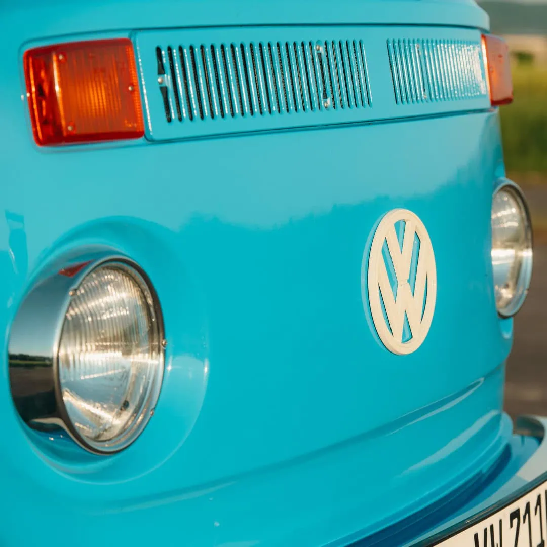 Nahaufnahme der Vorderseite des blauen Volkswagen-Transporters mit VW-Logo und Scheinwerfern.
