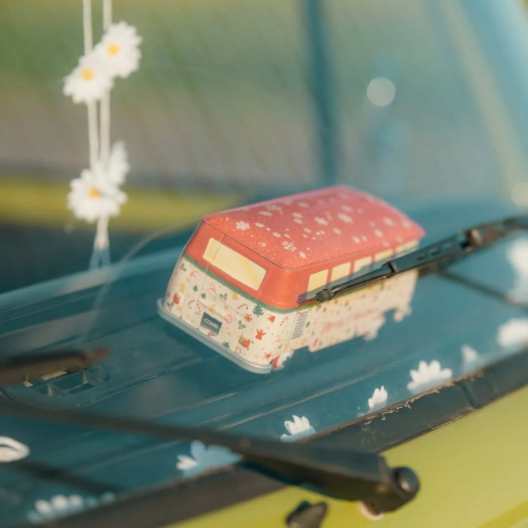 Kleiner Spielzeugtransporter auf dem Armaturenbrett mit Gänseblümchen-Deko.